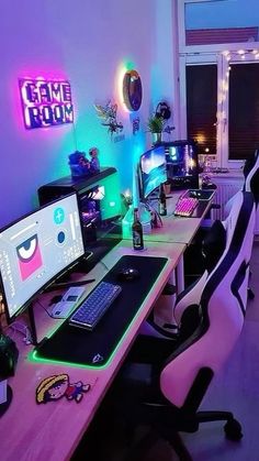 a computer desk topped with two monitors and a laptop next to a neon sign that reads creme room