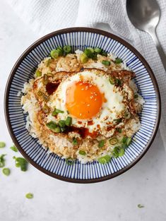 an egg sits on top of rice in a bowl