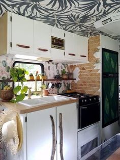 a kitchen with white cabinets and black and white wallpaper on the ceiling is decorated with zebra print