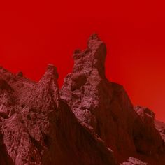 a red sky over some mountains and rocks