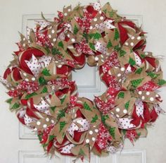 a christmas wreath with red and white bows hanging on the front door to give it a festive feel