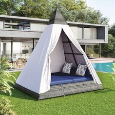 a white tent sitting on top of a lush green field next to a swimming pool