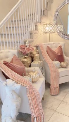 a living room filled with white furniture and pink pillows on top of it's covers