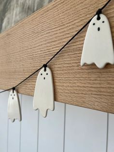 three ceramic ghost decorations hanging on a string