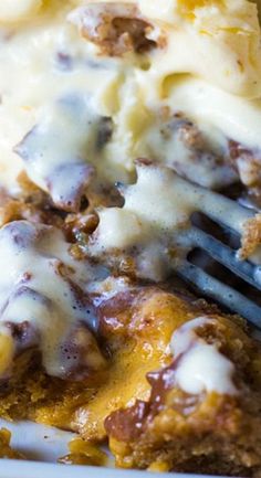 a close up of a plate of food with cheese and sauce on it, with a fork in the middle