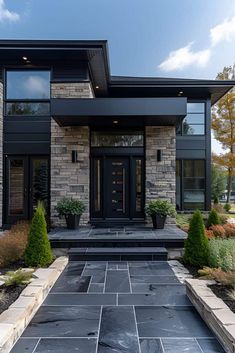 a modern house with stone and black accents on the front door, windows, and walkway