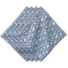 four napkins with blue and white floral designs on the front, one folded up to show