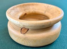 a wooden bowl sitting on top of a green table