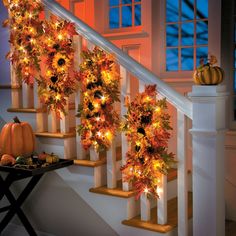 the stairs are decorated with fall leaves and pumpkins