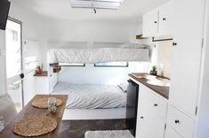 the interior of a tiny home with bunk beds and kitchenettes on each side