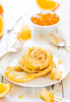 a plate with some food on it next to oranges and silverware in the background