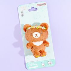 a brown teddy bear with a flower crown on its head sitting in a card package