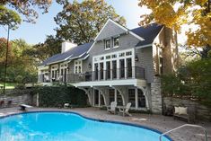 a large house with a swimming pool in the front yard and deck on the other side