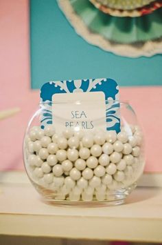 a glass bowl filled with white balls on top of a table