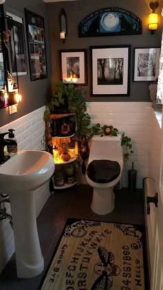 a bathroom with pictures on the wall and a rug in front of the sink area