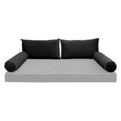 a black and white couch with two pillows on top of it, sitting next to each other