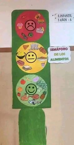 an art project made out of green paper with smiley faces on the front and sides