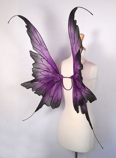 a white mannequin with purple wings on it