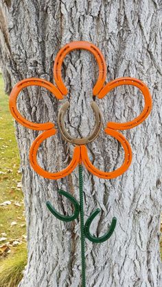 an orange flower is attached to the side of a tree with horseshoes on it