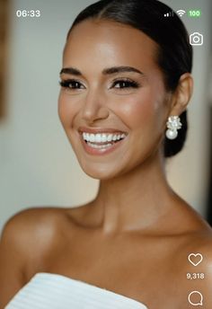 a woman in a white dress smiling at the camera