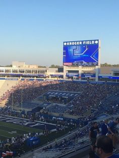 a stadium filled with lots of people sitting on the bleachers watching a football game