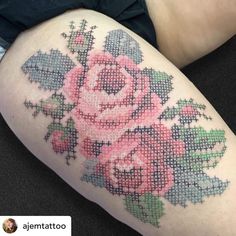 a close up of a person's thigh with a cross stitch tattoo on it