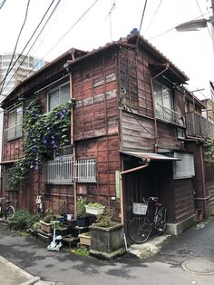 an old wooden building with vines growing on it's roof and balconies