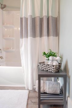 a bathroom with a white shower curtain next to a bath tub