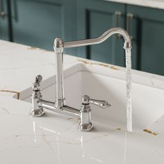 a faucet with water running from it's spout in a kitchen