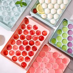 four trays filled with different types of food on top of a white countertop