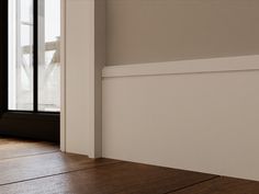 an empty room with wood flooring and white walls, looking out to the outside