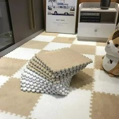 a stuffed animal sitting on top of a white and beige rug next to a window