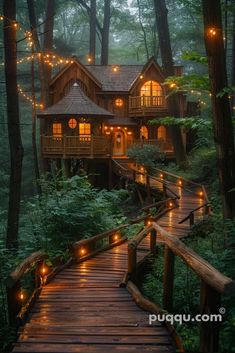 a wooden walkway leading to a cabin in the woods with lights hanging from it's roof