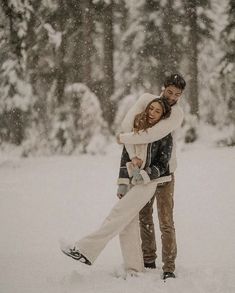 a man and woman hugging in the snow