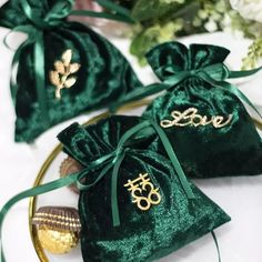 three velvet bags with gold initials on them