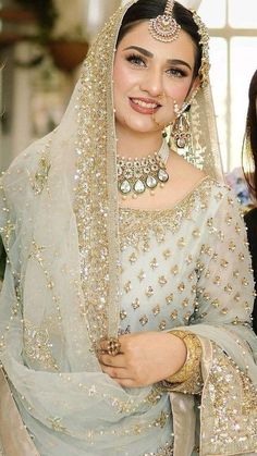 a woman wearing a bridal outfit and jewelry