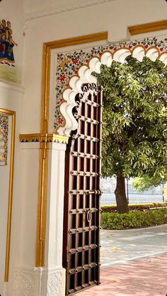 an open door to a building with a tree in the background