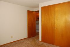 an empty room with wooden doors and carpet