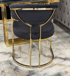 a black and gold chair sitting on top of a marble floor next to a table