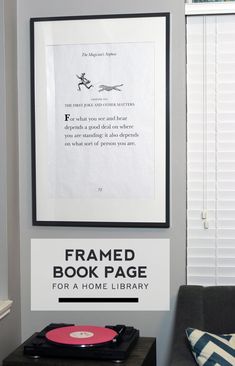 the framed book page for a home library is displayed above a record player on a table