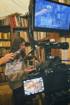 a woman holding a video camera in front of a television