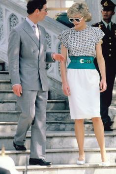 a man and woman are standing on the steps