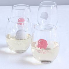 three wine glasses with elephants on them sitting on a white tablecloth covered table top