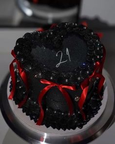 a heart shaped cake with red ribbon around it