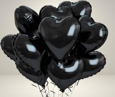 a bunch of black heart shaped balloons