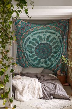 a bed with a tapestry hanging on the wall