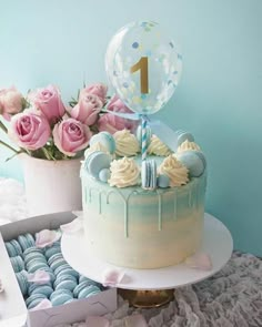 a birthday cake with frosting, balloons and flowers in the box next to it