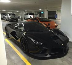 two black and orange sports cars parked in a parking garage with yellow lines on the floor