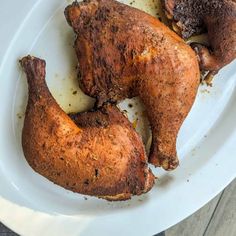 two pieces of chicken sitting on top of a white plate