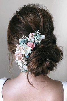 a woman with flowers in her hair is wearing a flowered headpiece on her back